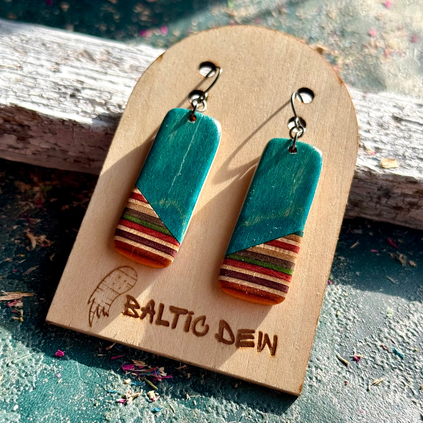 Turquoise recycled skateboard rectangle drop earrings displayed on a Baltic Dew wooden earring card.