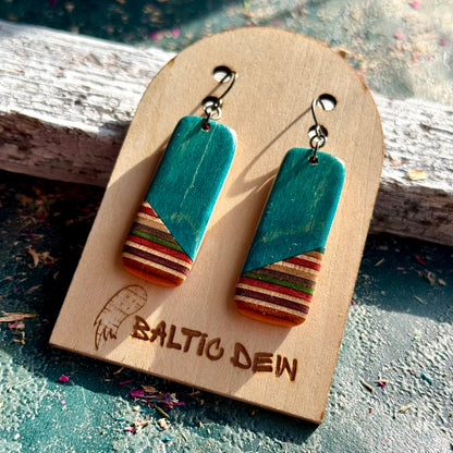 Turquoise recycled skateboard rectangle drop earrings displayed on a Baltic Dew wooden earring card.