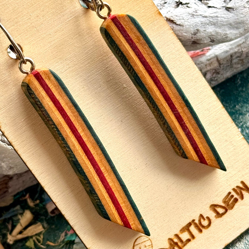 Close view of red, cream and blue striped skateboard wood long drop earrings, by Baltic Dew