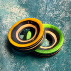 Orange and green wooden ear tunnels cut from a recycled skateboard, layered maple around the bore.
