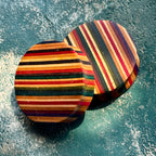 Pair of round plugs with fine skateboard maple stripes running across the face.