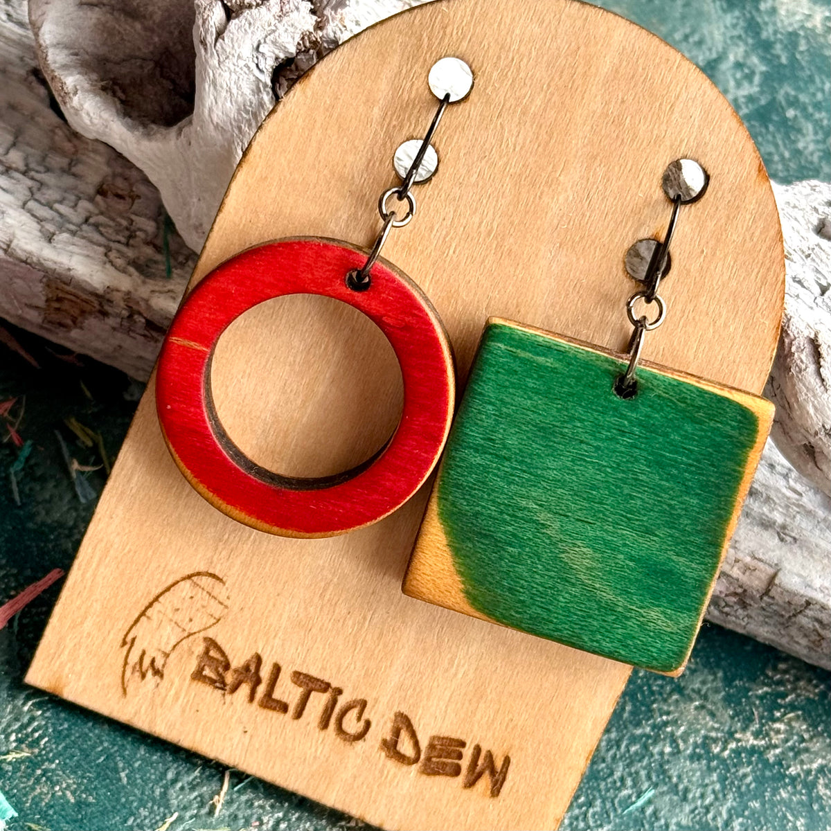 Mismatched skateboard wood earrings, a red ring paired with a green square, by Baltic Dew