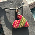 Pink and green striped wooden heart pendant from recycled skateboard maple on a black waxed cord.