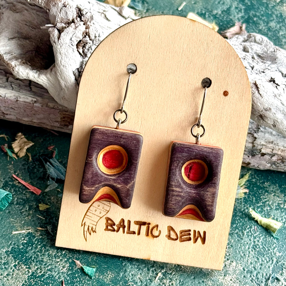 Purple carved skateboard wood earrings with a round red inlay, on surgical steel hooks