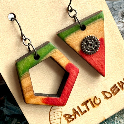 Close view of a green pentagon and a red triangle earring with a small decorative cog