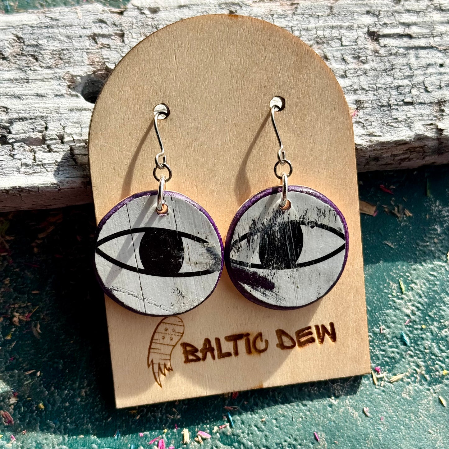 Round black and white skateboard wood earrings with cat eyes cut from the original deck artwork