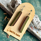Green and dark striped recycled skateboard wood long drop earrings hanging on a wooden card