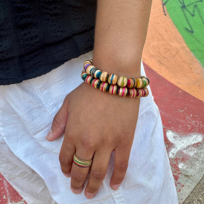 Recycled skateboard wood bead bracelets worn stacked on the wrist, colours vary with the deck they came from.