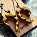 Yellow and black carved spiral earrings made from recycled skateboard maple on black hoops