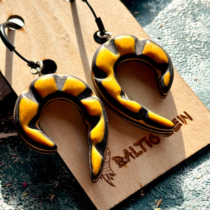 Yellow and black carved spiral earrings made from recycled skateboard maple on black hoops
