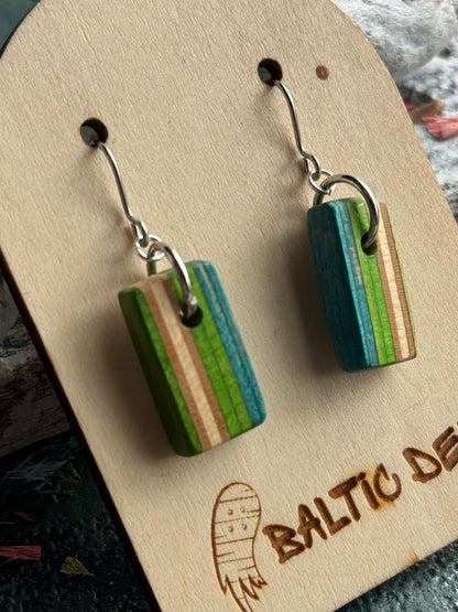 Close view of vertical green, teal and pale maple stripes in a recycled skateboard wood earring