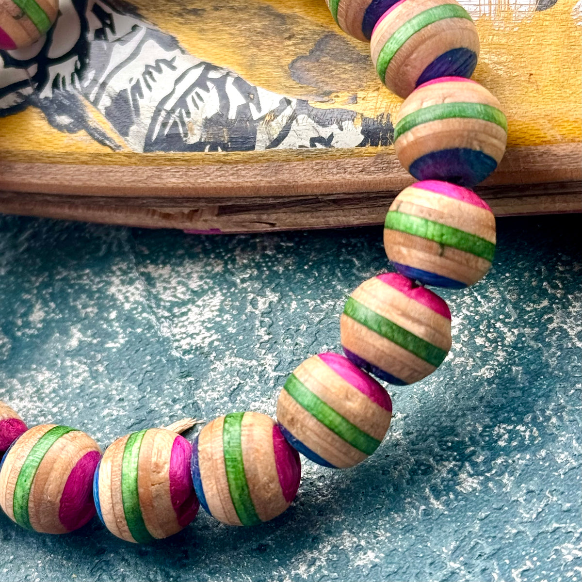 Wooden bead bracelet cut from a recycled skateboard deck in pink and green, handmade by Baltic Dew.