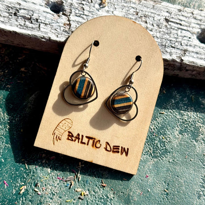 Recycled skateboard drop earrings with round layered maple inlays set inside open circular metal frames.
