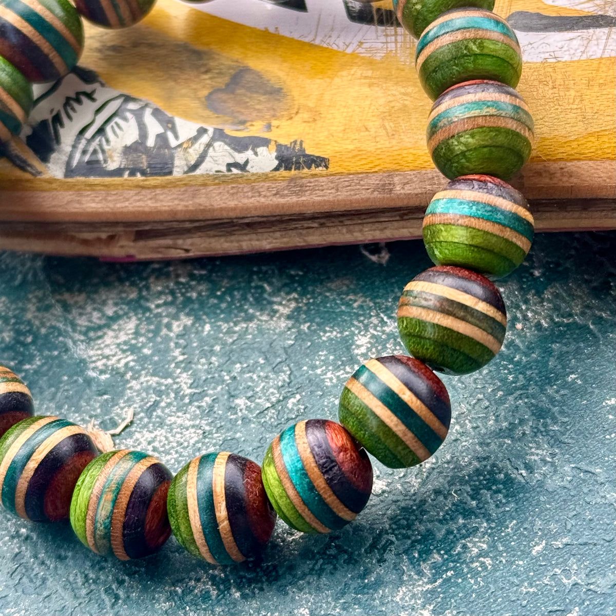 Green, teal and brown striped beads from recycled skateboard maple, handmade by Baltic Dew.