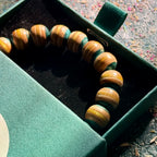 Light teal and yellow recycled skateboard wood bead bracelet in its green Baltic Dew gift box.