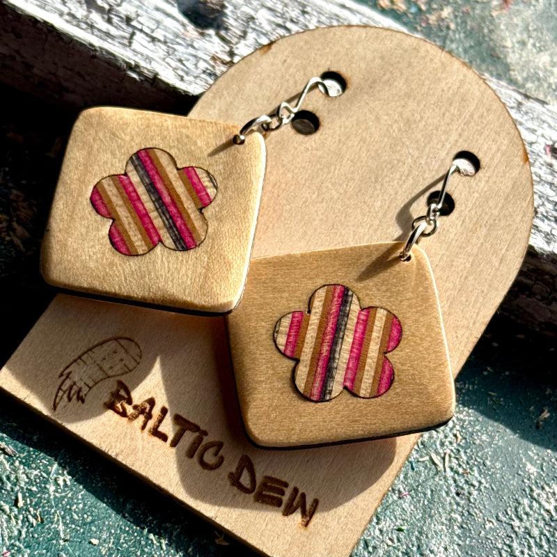 Beige recycled skateboard square drop earrings with flower cut-outs, showing pink, grey and cream layered maple.