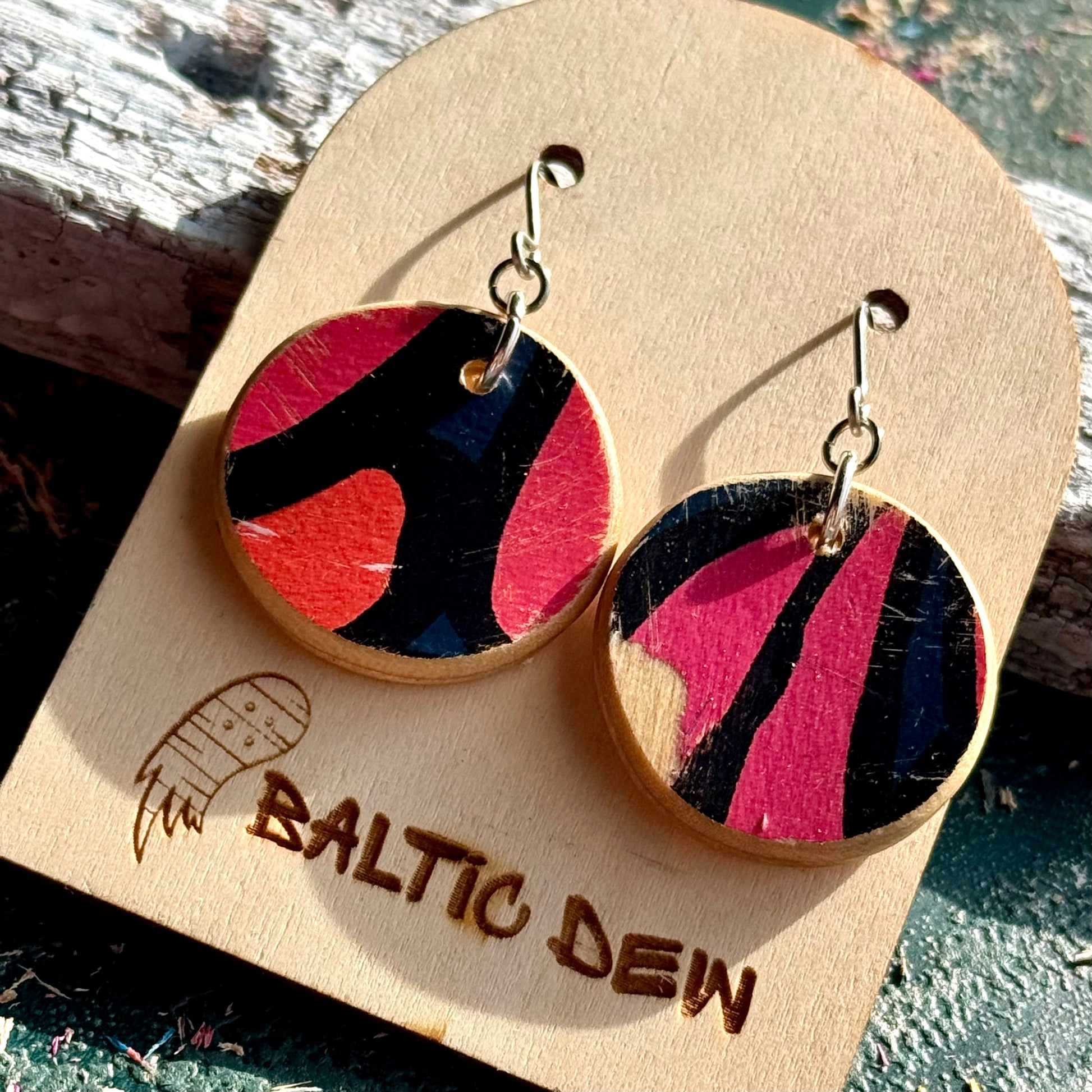 Pink and black recycled skateboard wood drop earrings with petal shapes from the deck graphic