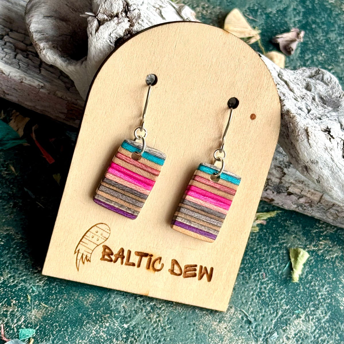 Small turquoise, pink and purple striped drop earrings cut across a recycled skateboard deck