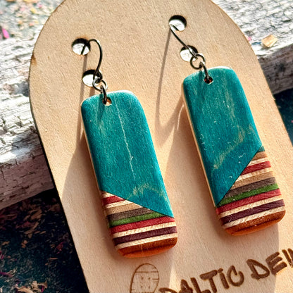 Turquoise recycled skateboard rectangle drop earrings showing layered maple colours and wood grain.