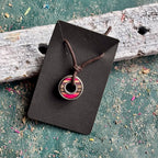 Pink and red striped skateboard bearing pendant in recycled maple on a brown waxed cotton cord.