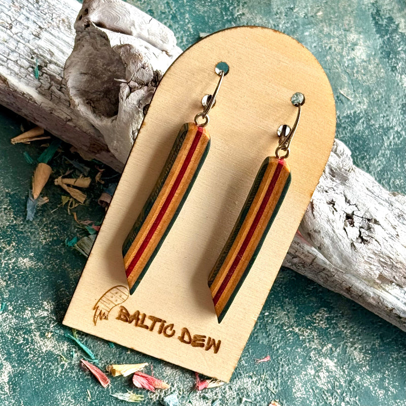 Red and orange striped recycled skateboard wood long drop earrings shown on a Baltic Dew card