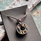 Black and natural maple skateboard bearing pendant on a brown waxed cotton cord, handmade by Baltic Dew.