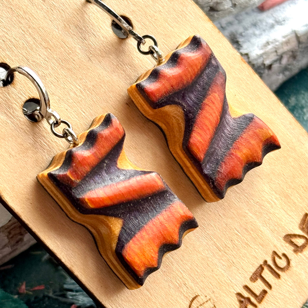 Close view of orange and purple zigzag wave earrings cut from recycled skateboard maple