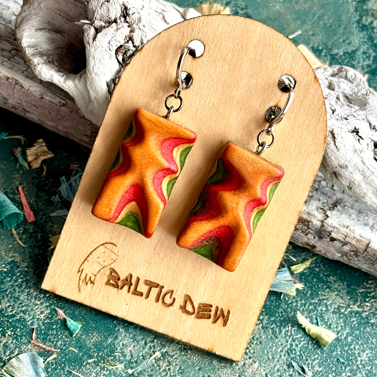 Carved skateboard wood wave earrings in orange, red and green with a sharp zigzag through the layers