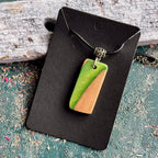 Green and natural maple skateboard wood pendant on a black waxed cord, handmade by Baltic Dew.
