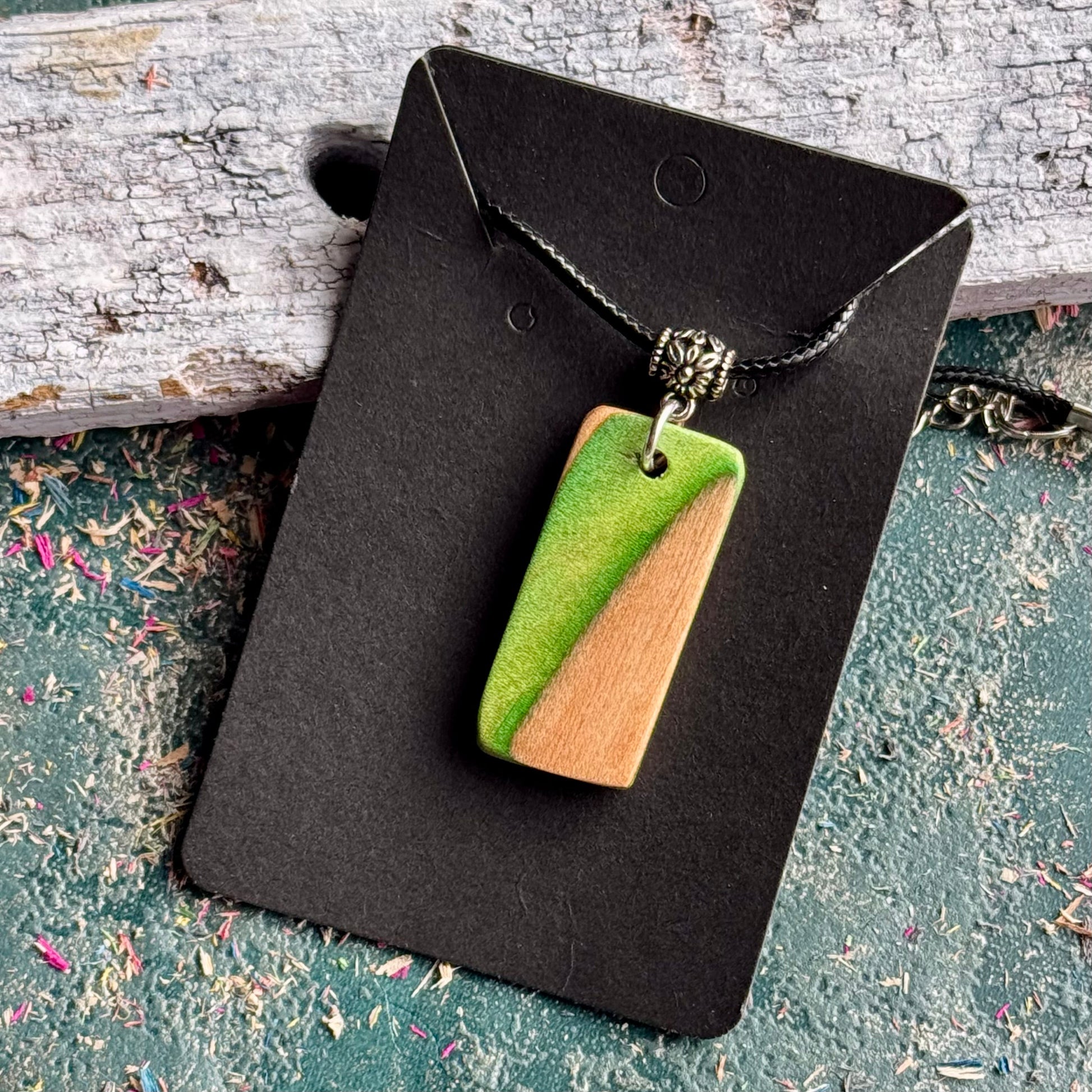 Green and natural maple skateboard wood pendant on a black waxed cord, handmade by Baltic Dew.