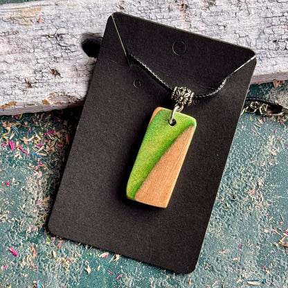 Green and natural maple skateboard wood pendant on a black waxed cord, handmade by Baltic Dew.