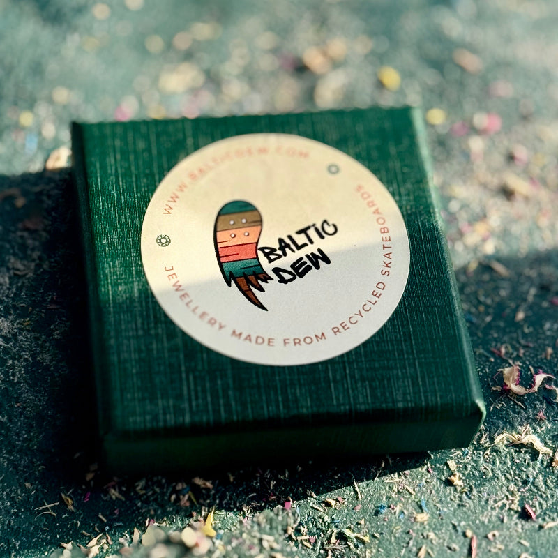 Green jewelry box with a 'Baltic Dew' label on a textured surface.