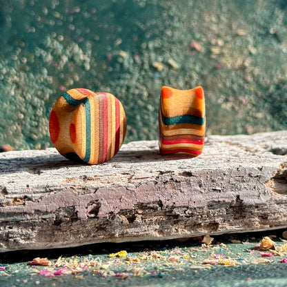 Red and brown double flare ear plugs at 16mm, cut from a recycled skateboard deck.