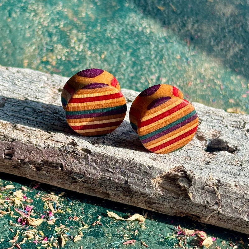 Red and purple double flare ear plugs at 16mm, striped layers from a recycled skateboard.