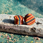 Red and purple 16mm ear plugs angled to show red, purple and natural maple layers.
