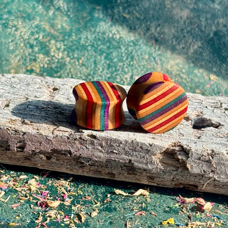 Red and purple 16mm ear plugs angled to show red, purple and natural maple layers.