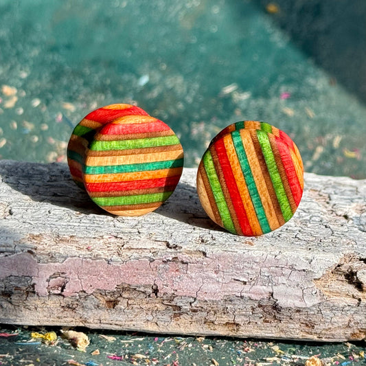 Green, Red and Orange Double Flare Wooden Ear Plugs 16mm with colorful striped wood pattern on a rustic surface