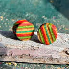 Green, red and orange double flare ear plugs at 16mm, cut from a recycled skateboard deck.