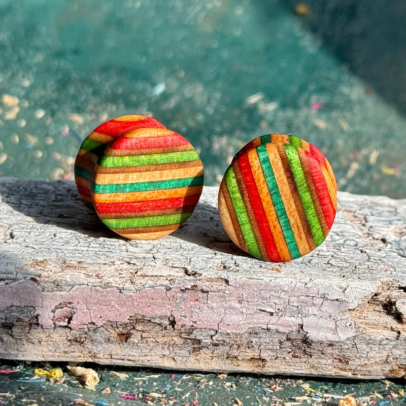 Green, red and orange double flare ear plugs at 16mm, cut from a recycled skateboard deck.