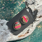 Grey and pink lightweight wooden stud earrings with visible layered grain.