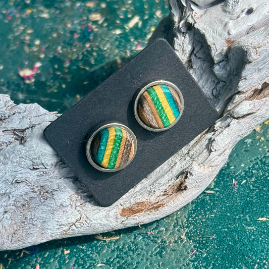 Green and yellow wooden stud earrings with visible skateboard colour layers and grain.