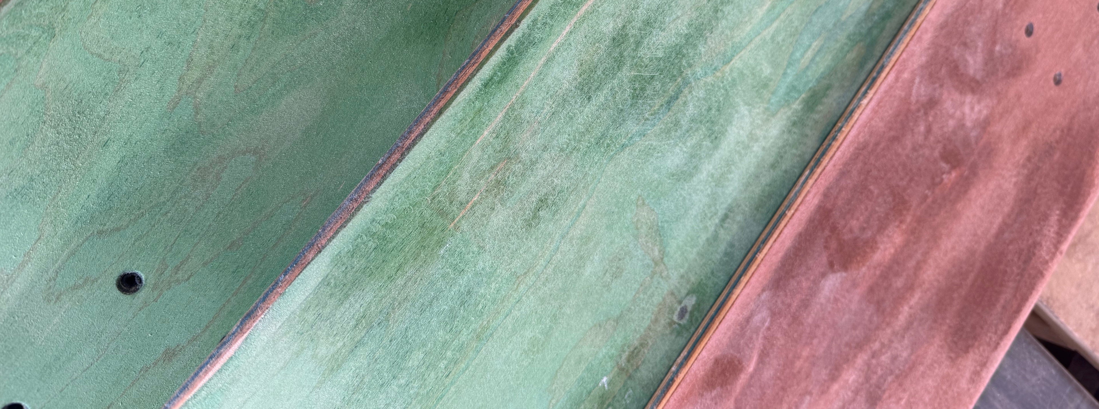 Close-up of a skateboard with green and brown deck