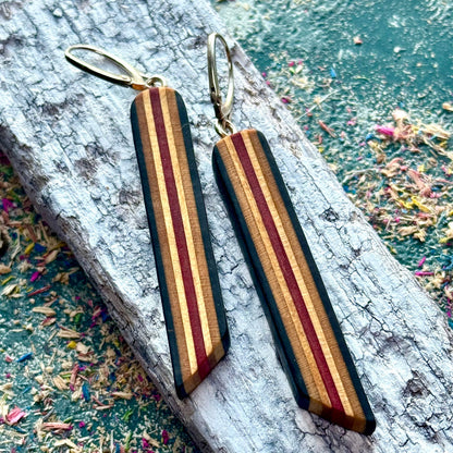 Wooden striped earrings on a textured surface