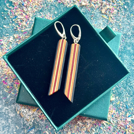 Wooden earrings in a green box with a glittery background