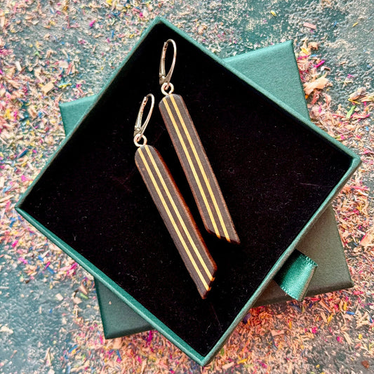 Pair of earrings in a green box on a textured surface