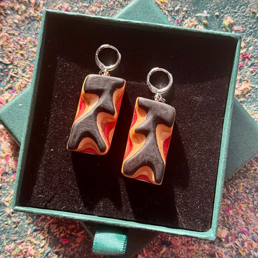 Pair of earrings in a green box with a colorful background