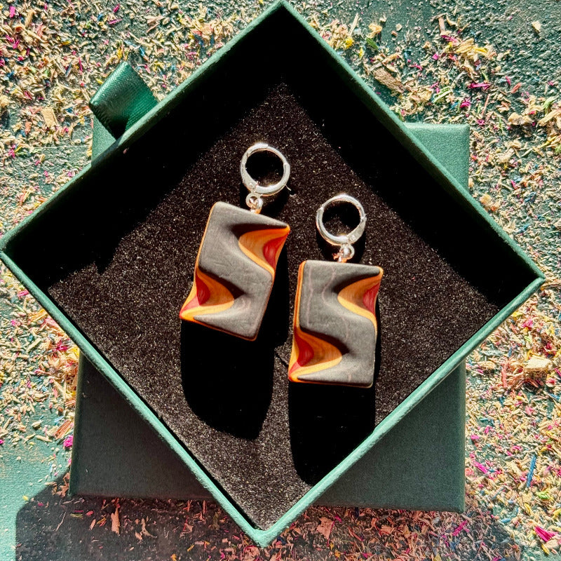 Pair of earrings in a green box with a textured surface