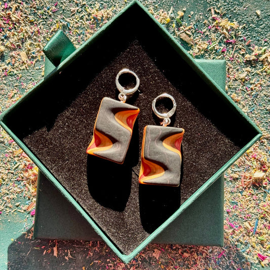 Pair of earrings in a green box with a textured surface