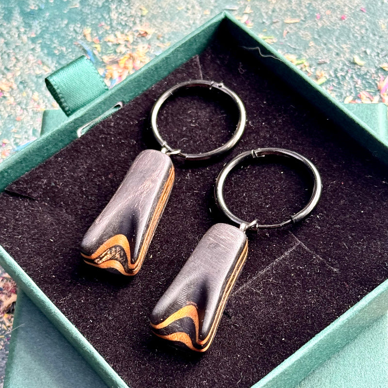 Rich black layered wood hoop earrings with natural maple details.