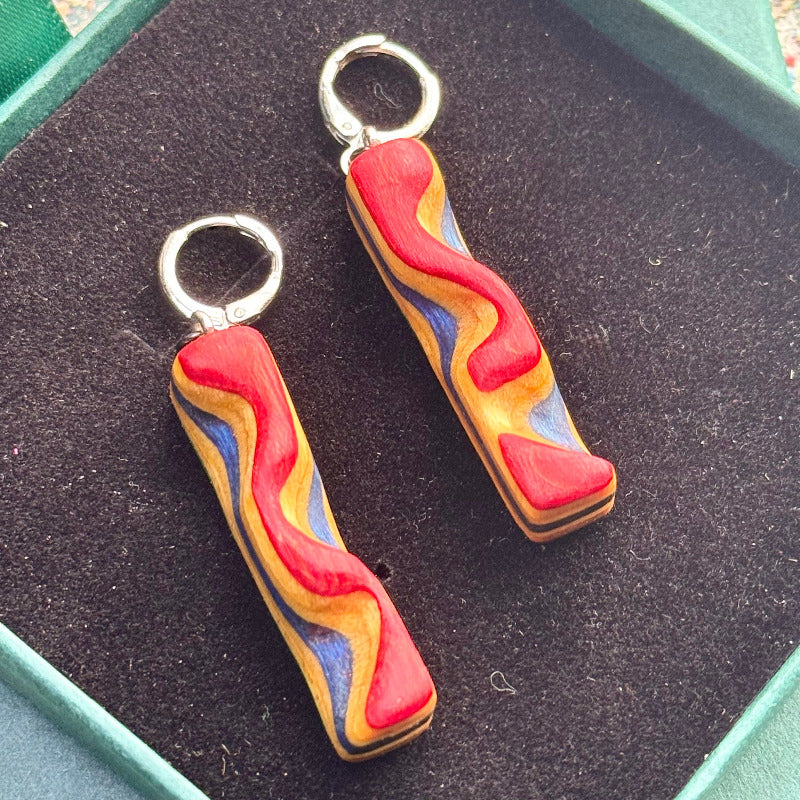 Colorful wavy earrings on a black background